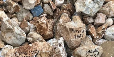 A Stack of Rocks Featuring Various Inscriptions on Their Surfaces, Arranged in a Natural Setting.